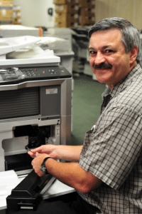 A Powers Business Machines man fixing copier
